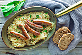 Sausages on sauerkraut in a copper pan