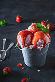 Strawberry ice cream with sauce and mint