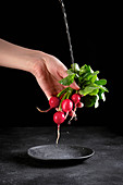 A bunch of radishes being washed