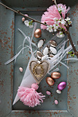 Romantische Osterdeko mit Schokoeiern und rosafarbenen Quasten