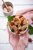 Vegan mini pancake bowl with berries, sugar syrup and chocolate