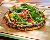 Pizza with Prosciutto, cherry tomatoes and rocket