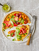 Tart with cheese filling and different kind of tomatoes