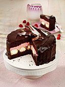Chocolate cake filled with raspberry cream and mini profiteroles