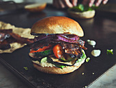 A grilled vegetable burger with vegan bacon