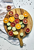 Various halved citrus fruits on wooden board