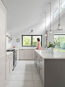 Modern country-house kitchen with pale grey cabinets and high ceiling