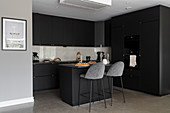 Fitted kitchen with island counter in dark charcoal grey