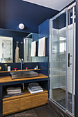 Wooden washstand in small bathroom with blue walls