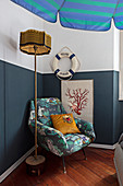 Sessel und maritime Deko an halbhoch blau gestrichener Wand
