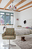 Double bed in bedroom with armchair in foreground