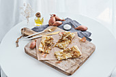 Puff pastry with onion and cream cheese placed on rustic cutting board