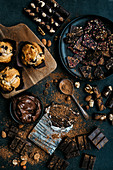Stilleben mit Muffins, Schokolade, Nüssen und Kakaopulver
