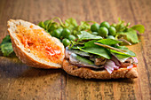 Opened traditional harvest sandwich with sardines, meat and different vegetables
