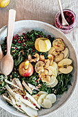 Winter salad with kale, apples, pomegranate seeds and a candle