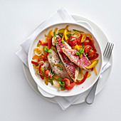 Oven-roasted red mullet fillets with a pepper medley and cherry tomatoes