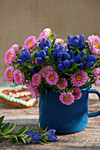 Closed Gentiana with summer asters in an enamel pot