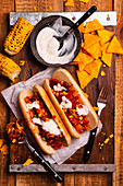 Hot dogs with Mexican sauce sweet corn red beans and nachos