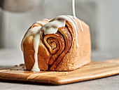 Glazing a cinnamon roll cake with icing
