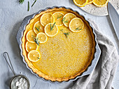 Lemon tart garnished with lemon wedges and rosemary