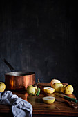 Stillleben mit Äpfeln und Kupfertopf auf Holztisch