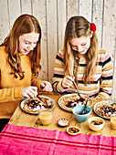 Zwei Mädchen dekorieren Pfannkuchen