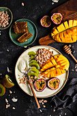 Smoothie bowl with matcha, mango, passion fruit, kiwi and expanded spelled