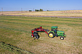 Tractor raking hay