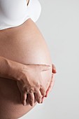 Pregnant woman holding her abdomen