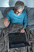 Mature woman making a video call on her laptop