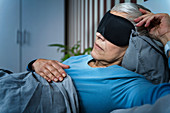 Mature woman wearing black sleep mask