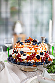 Meringue cake with autumnal berries on a cake stand