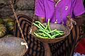 Abwiegen von grünen Bohnen auf Marktstand in Sri Lanka