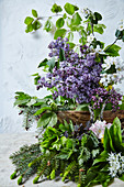 A spring flower arrangement with lilac, fruit blossom, leaves and needles