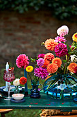 Dahlias in blue glass vase on set table outdoors