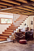 Wooden staircase, banister made of recycled copper pipes, vintage leather armchair and desk