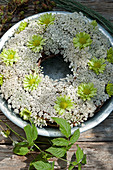 Wreath of Queen Anne's lace and green chrysanthemums in zinc dish