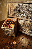 High angle of weathered old drawer with dried flower petals and herbs placed on table