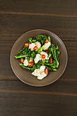 Fresh green broccolini and white cheese with chopped dried tomatoes