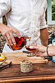 Barkeeper holding crystal decanter and pouring bourbon in glass