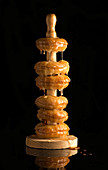 Fried doughnuts on wooden holder, covered with shiny golden honey