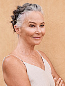 A grey-haired woman with a braided hairstyle