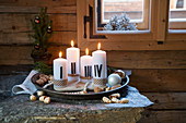 Advent arrangement of candles painted with Roman numerals on tray