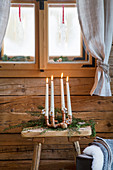 Advent arrangement of four tapered candles in copper-pipe candle holder