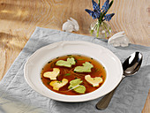 Traditional beef bouillon with egg shapes for Easter