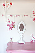 White vanity mirror on pink cabinet