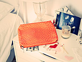 Orangefarbene Kosmetiktasche auf Nachttisch