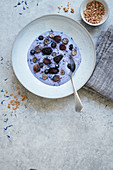 Blaue Matcha-Kokos-Bowl mit frischen Beeren und Hafergranola