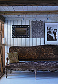 Antique Baroque sofa against board wall in rustic wooden house