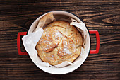 Homemade round Artisan bread freshly baked in an enamel cast iron Dutch oven.
